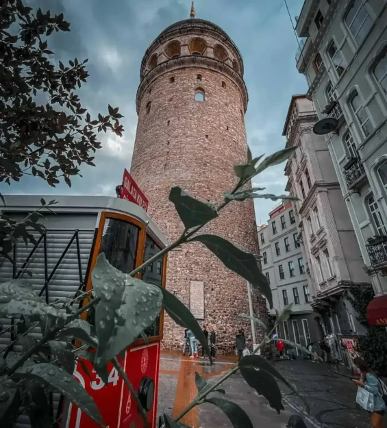 İstanbul'daki Galata Kulesi, eski bir tramvayın bulunduğu sokaktan görülüyor. Tarihi Galata manzarası. _by fotoloji