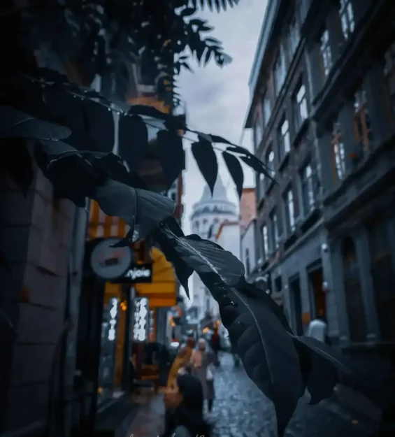 Yağmurlu sokakta yürüyen genç bir kızla Galata Kulesi manzarası _by fotoloji