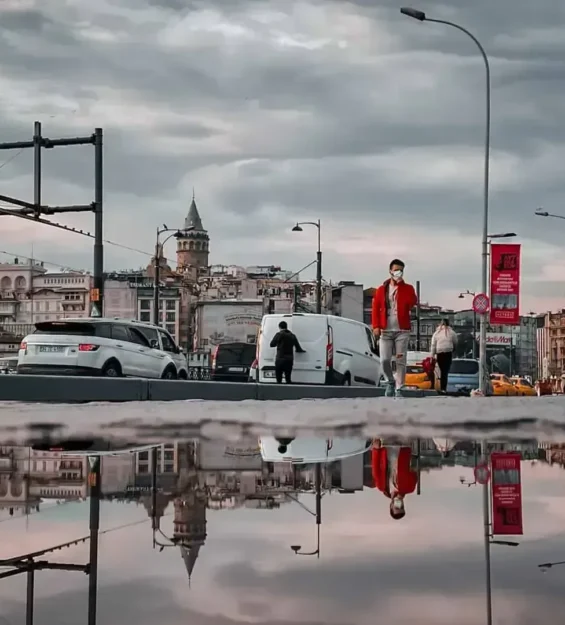 Galata Kulesi ve yağmurla ıslanmış bir şehir manzarasında yansıma, yürüyen insanlar _by fotoloji