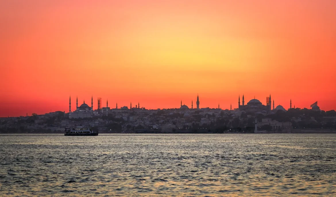 Canlı bir gün batımının önünde silüet halinde görünen İstanbul silüeti. Romantik bir gün batımı atmosferi.