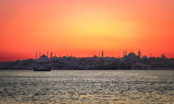 Canlı bir gün batımının önünde silüet halinde görünen İstanbul silüeti. Romantik bir gün batımı atmosferi.