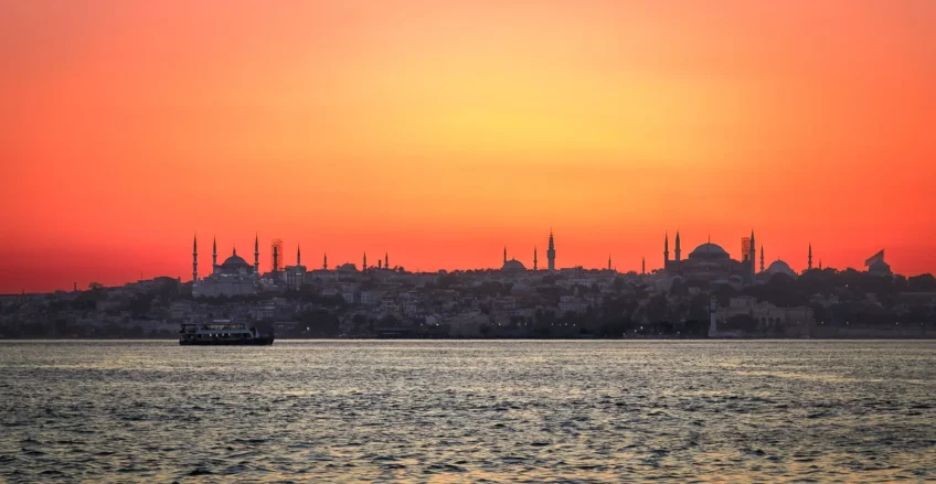 Canlı bir gün batımının önünde silüet halinde görünen İstanbul silüeti. Romantik bir gün batımı atmosferi.