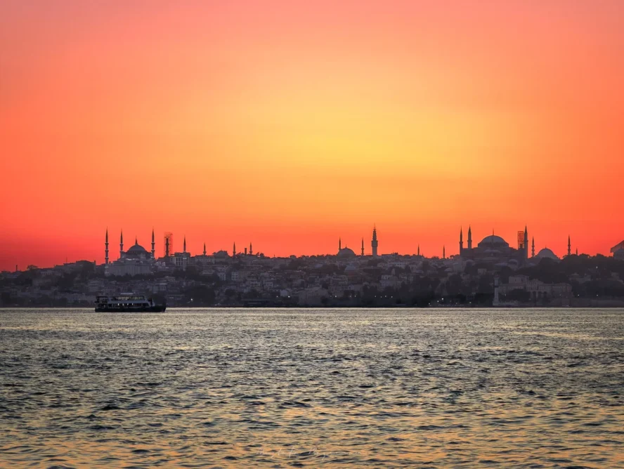 Canlı bir gün batımının önünde silüet halinde görünen İstanbul silüeti. Romantik bir gün batımı atmosferi.