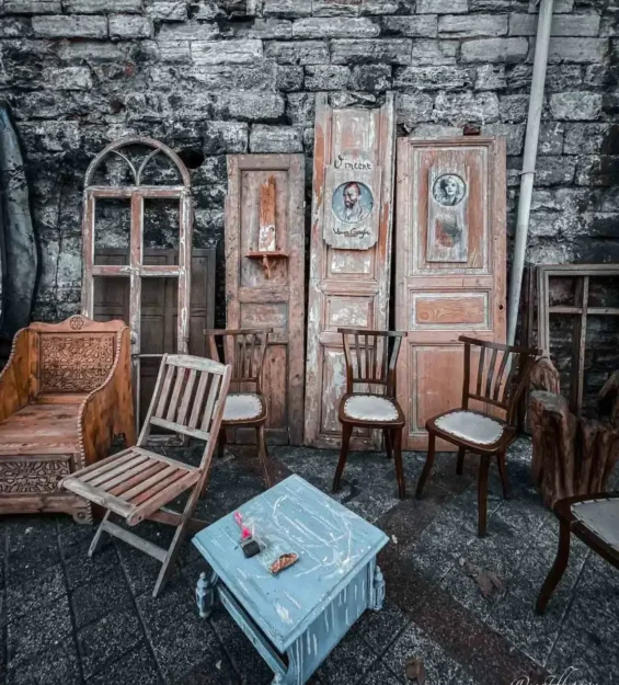 Balat'ta taş duvar önünde antika sandalyeler ve masa, Balat kültürünü ve tarihini sergiliyor. _by fotoloji