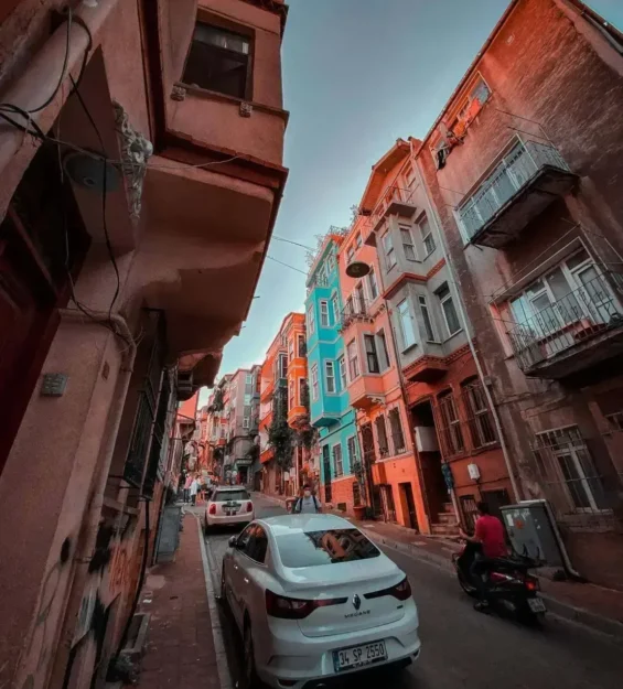 Dar bir sokakta rengarenk Balat evleri, arabalar ve scooterlar sıralanıyor. Balat tarihi. _by fotoloji