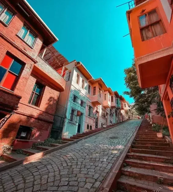 Balat'ta Arnavut kaldırımlı bir sokakta sıralanan renkli tarihi evler _by fotoloji