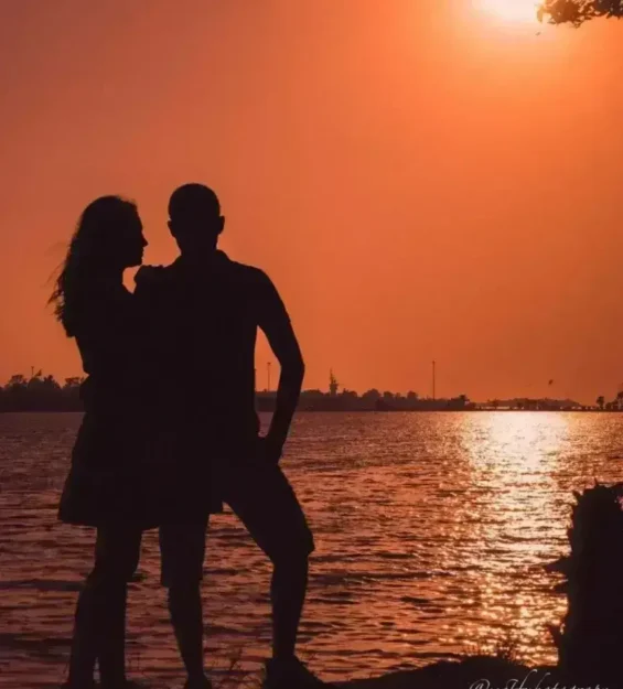 Romantik bir gün batımında, nefes kesen gün batımı atmosferinin tadını çıkaran, birbirlerine sarılan bir çiftin silüeti. by fotoloji