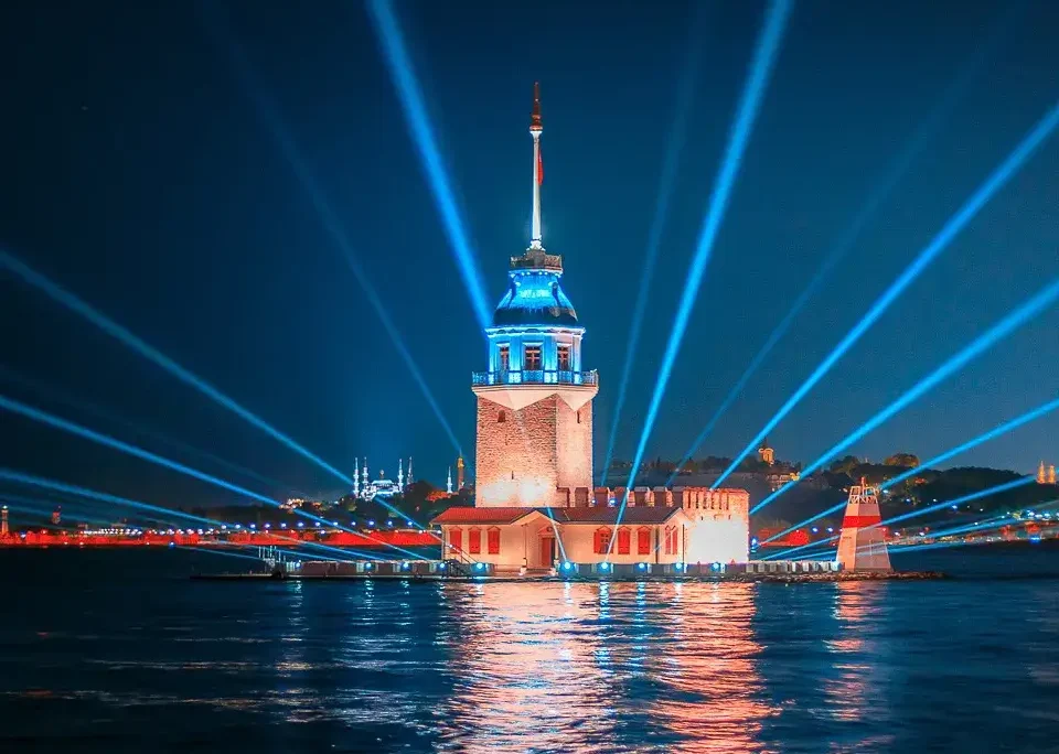 Istanbuldaki Kiz Kulesi Gece Gokyuzune Yayilan Isinlar Ve Sudaki Yansimalarla Mavi Isiklarla Aydinlatilmis
