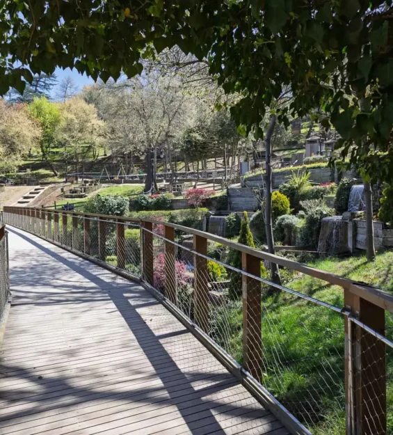 Peyzaj düzenlemesi ve küçük şelaleleri olan bir parkta ahşap yaya köprüsü by fotoloji