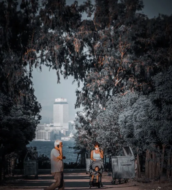 Telefonda yaşlı bir adam, bebek arabası ve çocuğu olan kadın, arka planda şehir silüeti. by fotoloji