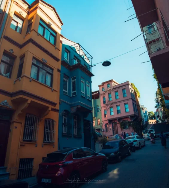 Dar bir sokakta, arabaların ve güneş ışığının olduğu rengarenk Balat evleri _by fotoloji