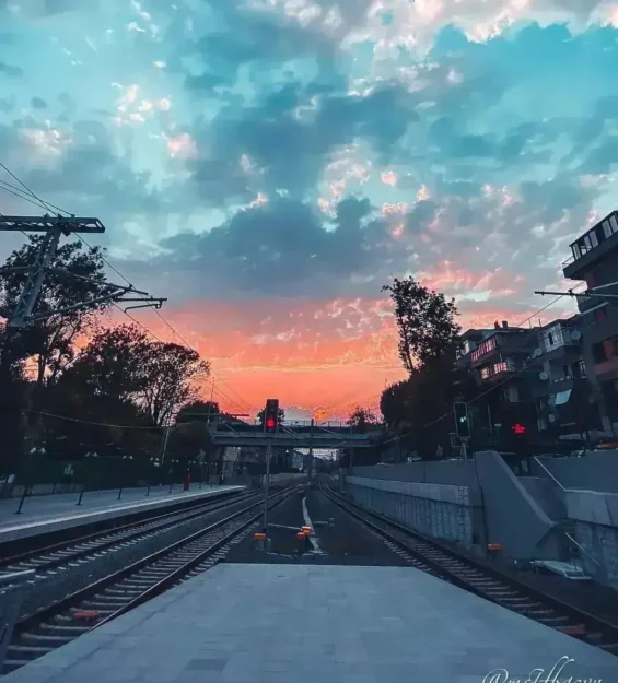 Renkli gökyüzüyle şehir tren raylarının üzerinde canlı gün batımı _by fotoloji