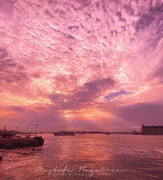Dağınık bulutlarla sakin bir limanın üzerinde canlı pembe gün batımı _by fotoloji