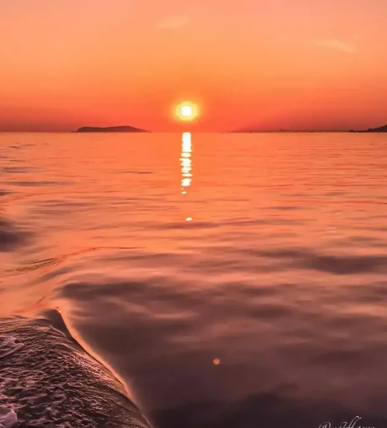 Sakin okyanus suyunun üzerinde muhteşem gün batımı, güneşin dalgalara yansıması. _by fotoloji
