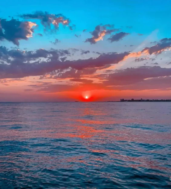 Sakin bir okyanusun üzerinde, renkli gökyüzü ve bulutlarla canlı bir gün batımı _by fotoloji