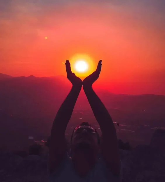 Canlı bir gün batımına karşı kolları havada silüeti görünen kişi _by fotoloji