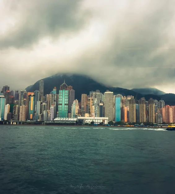 Hong Kong manzaraları: Liman üzerindeki gökdelenler ve bulutlu gökyüzü _by fotoloji