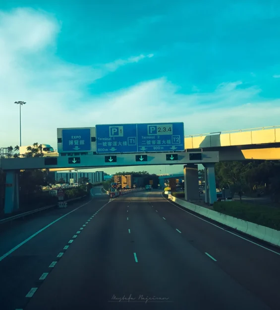 Hong Kong'da mavi gökyüzü, yeşilliklerle çevrili, kentsel altyapıyı sergileyen otoyol _by fotoloji
