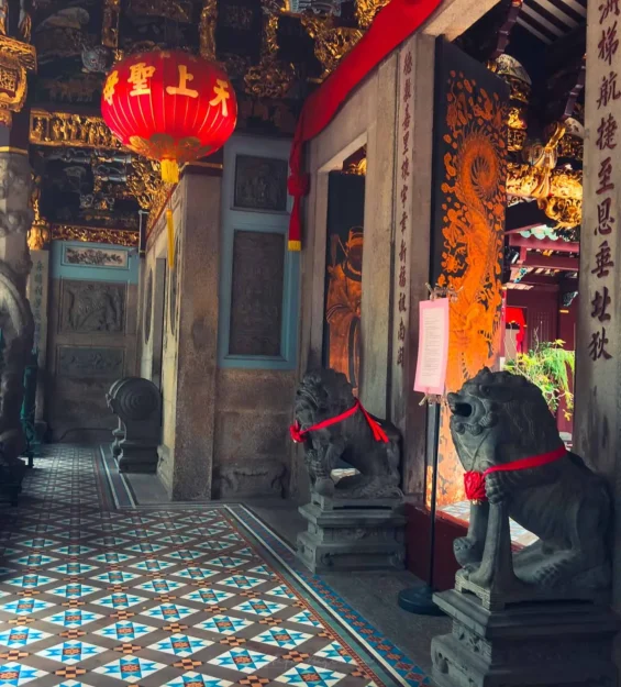 Geleneksel mimari, taş aslan heykelleri ve kırmızı bir fenerin yer aldığı Singapur tapınağının süslü girişi. Singapur kültürü. _by fotoloji