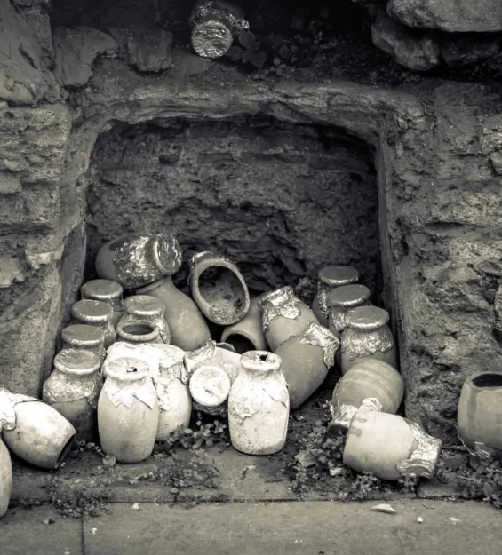 Taş bir oyukta saklanan, bazıları folyo ile kapatılmış kil kaplar ve kavanozlardan oluşan yığın. _by fotoloji