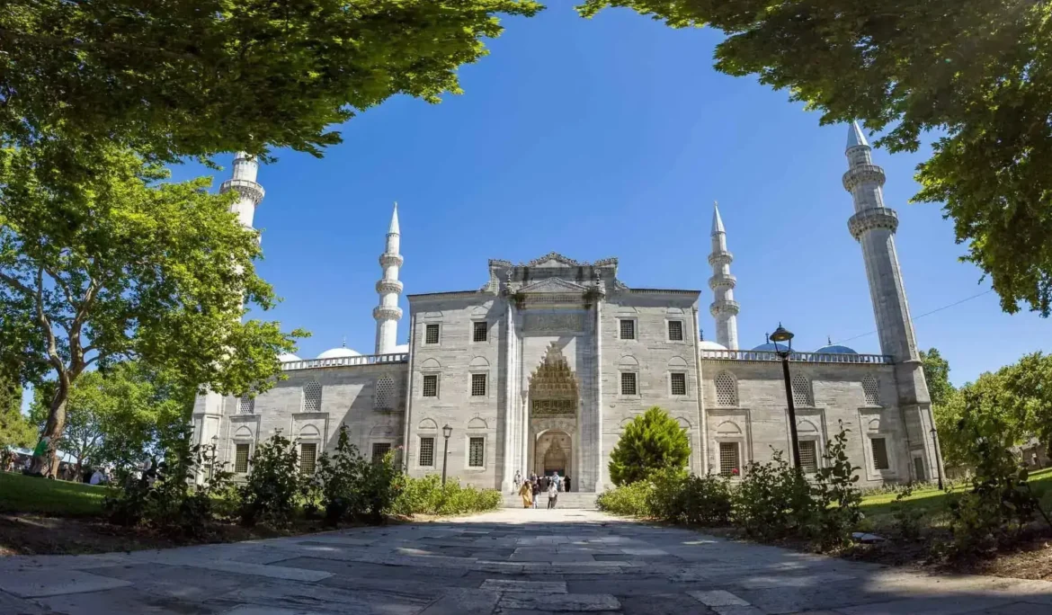 Türkiye'nin İstanbul kentindeki Süleymaniye Camii, ağaçlarla çevrili ve masmavi gökyüzünün altında.