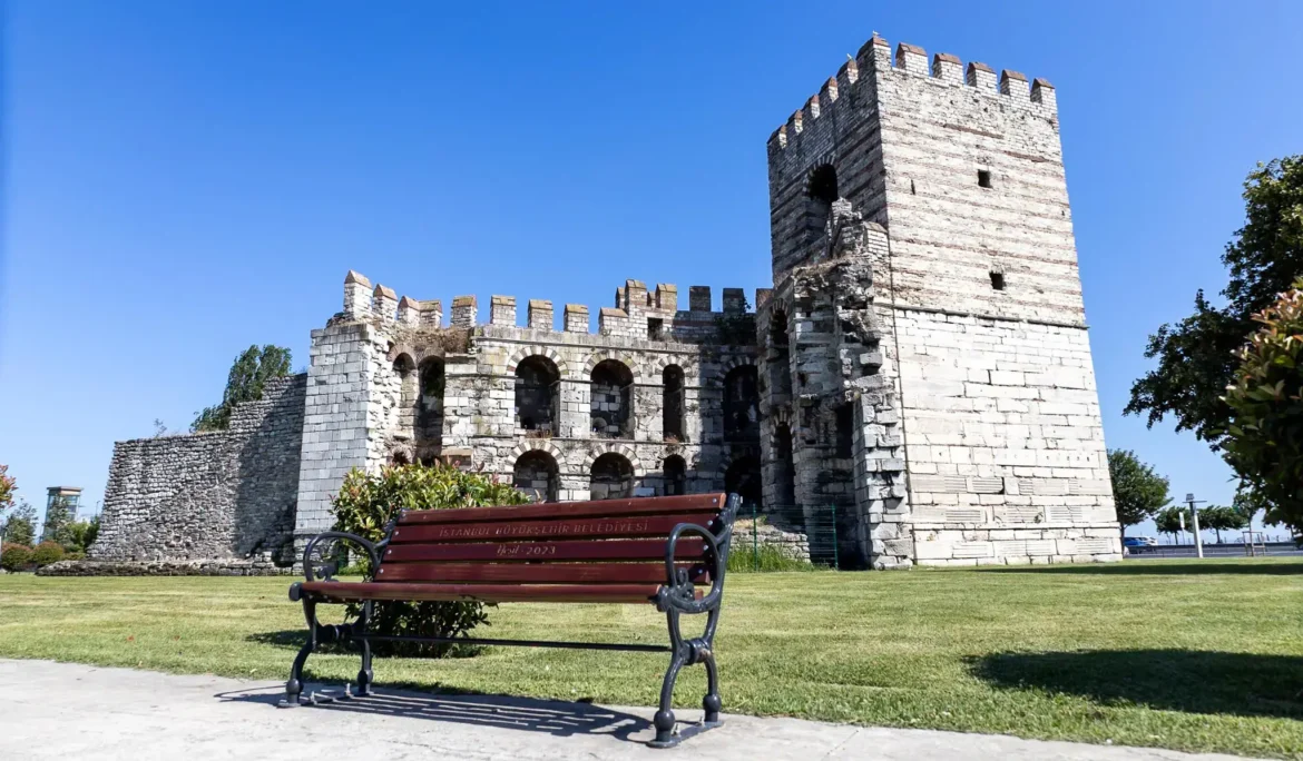 Türkiye'nin İstanbul kentindeki antik Bizans surları, ön planda bir park bankı ile.
