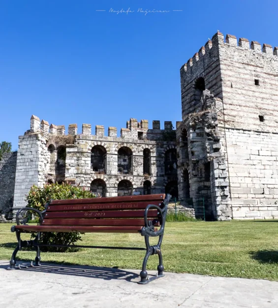 Türkiye'nin İstanbul kentindeki antik Bizans surları, ön planda bir park bankı ile.