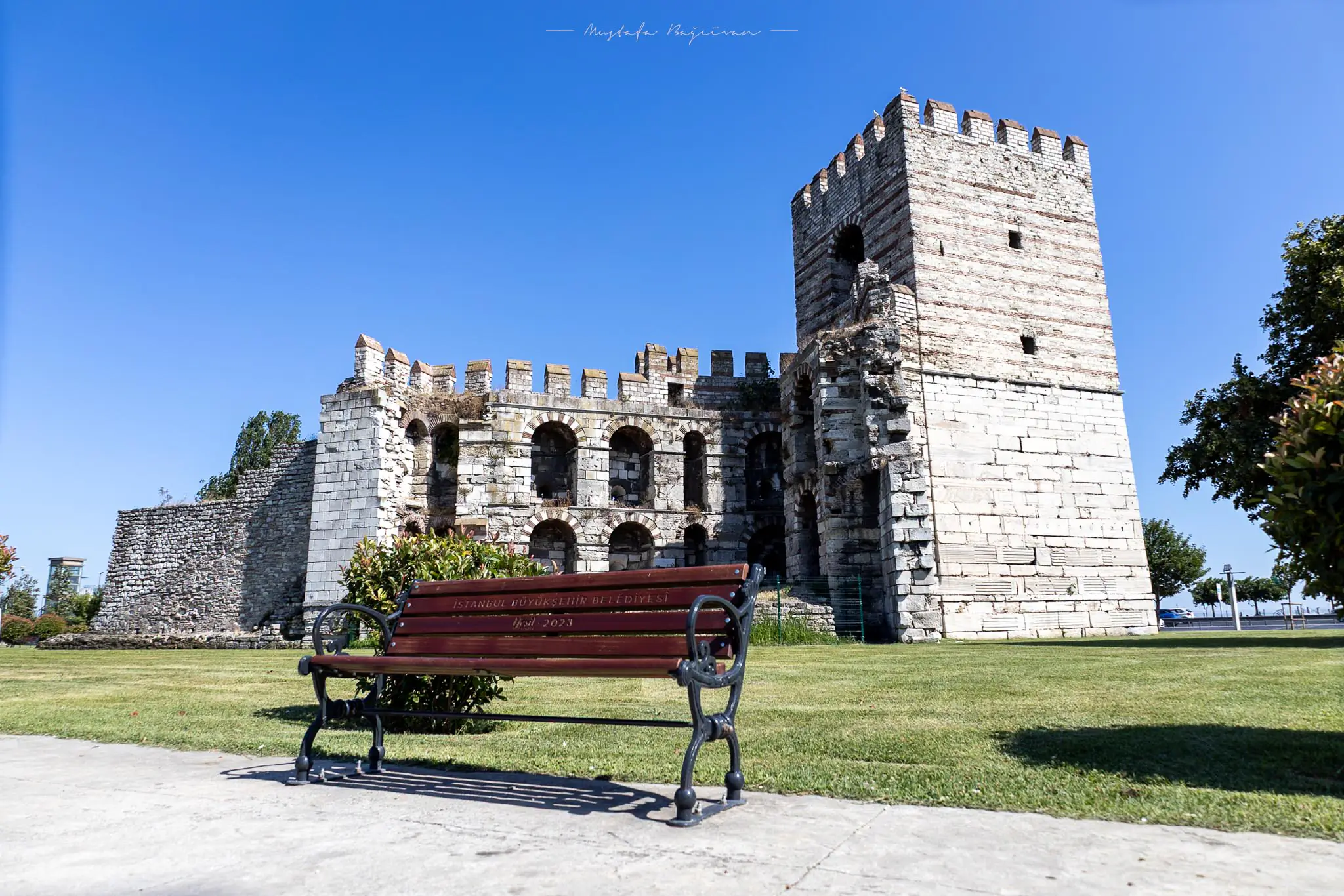 Türkiye'nin İstanbul kentindeki antik Bizans surları, ön planda bir park bankı ile.