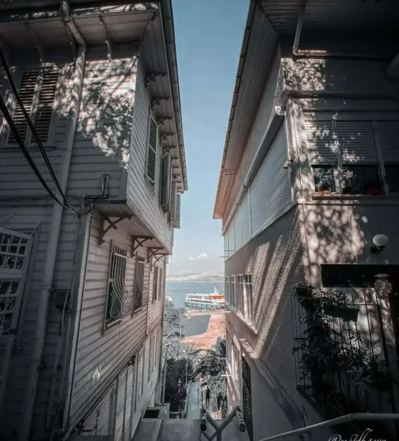 Ahşap binaların arasında, vapur ve denize bakan dar İstanbul sokağı.