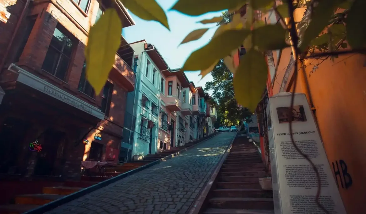İstanbul Fener'de tarihi evleri ve bilgilendirici tabelalarıyla dik Arnavut kaldırımlı sokak.