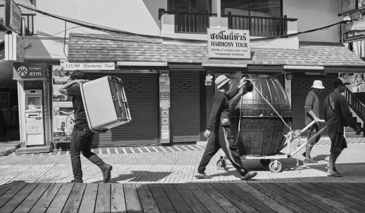 grayscale photo of man and woman walking on wooden pathway