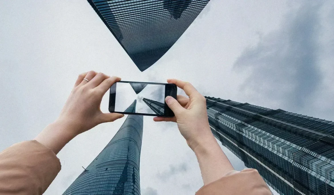 Akıllı telefonuyla Şanghay gökdelenlerinin fotoğrafını çeken kişi. Benzersiz mimariyi yakalıyor.