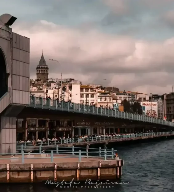 Türkiye, İstanbul'daki bir köprüden Galata Kulesi manzarası. Sahil boyunca restoranlar sıralanıyor.