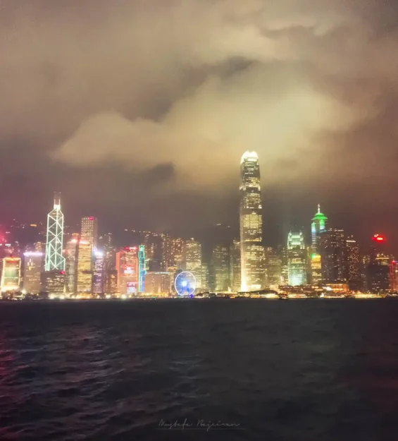 Hong Kong'un gökdelenleri ve limanıyla birlikte gece manzarası.