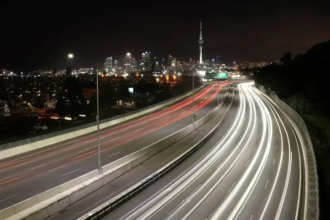 Yeni Zelanda'nın Auckland şehrinin Sky Tower ve otoyol ışıklarıyla gece manzarası.