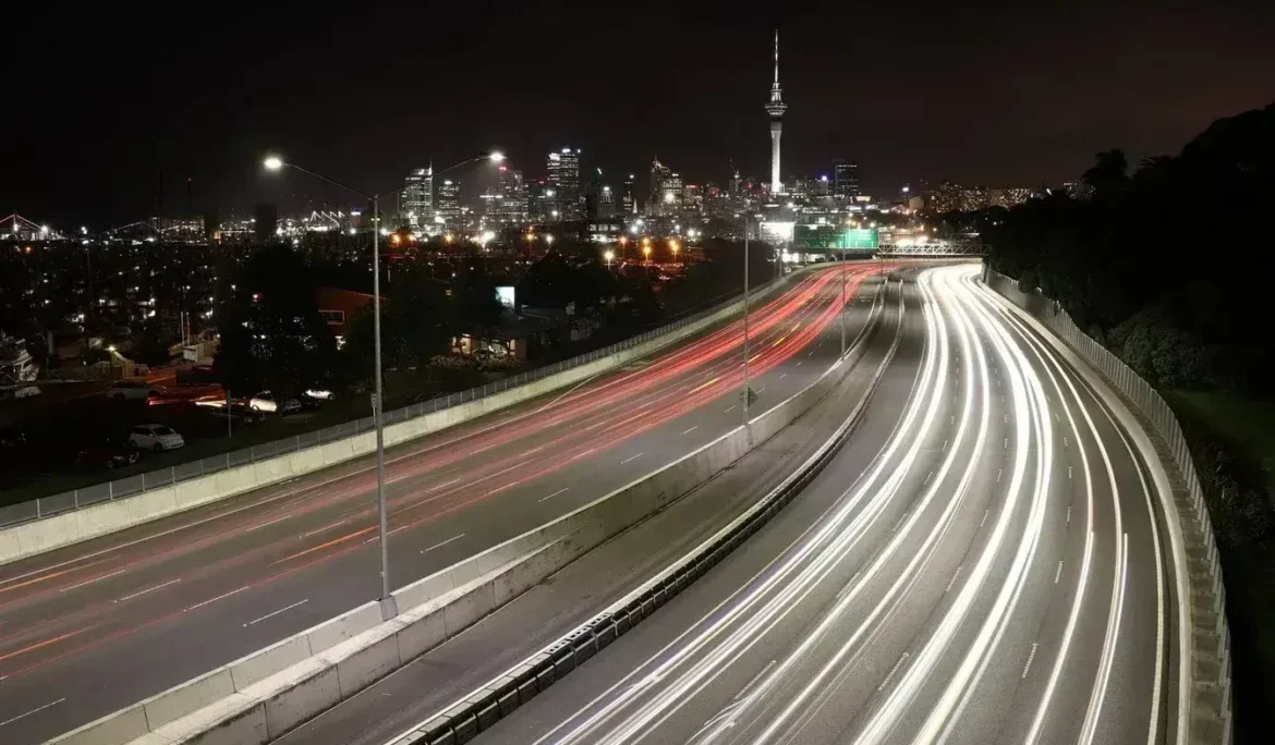 Yeni Zelanda'nın Auckland şehrinin Sky Tower ve otoyol ışıklarıyla gece manzarası.