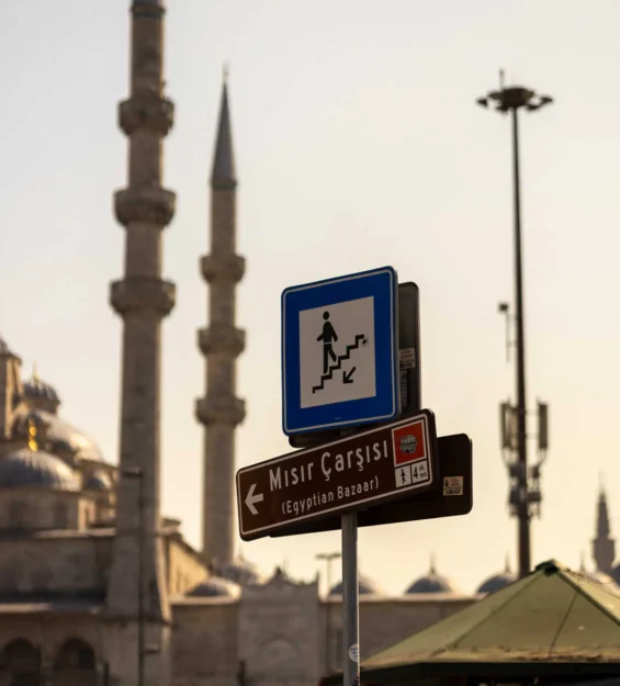 İstanbul sokak tabelası: Mısır Çarşısı (Mısır Çarşısı), merdivenleri ve yönü gösteriyor. Arka planda Yeni Cami.