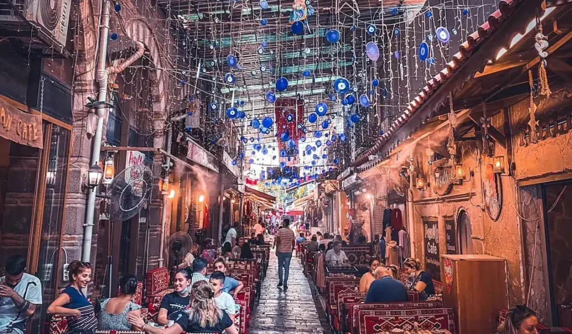 Mavi nazar boncuklarıyla süslenmiş, kafelerle çevrili dar Türk sokağı.