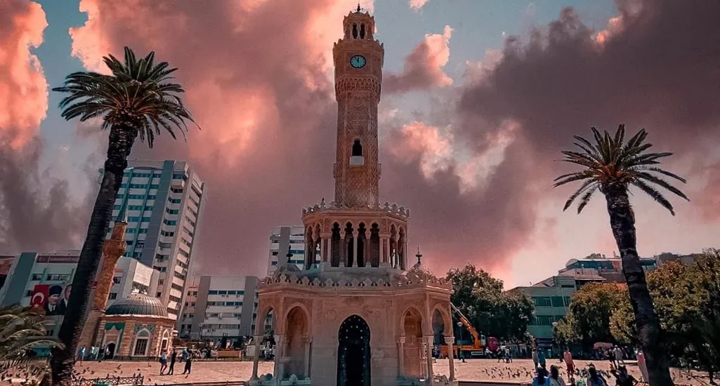 Türkiye'nin Konak Meydanı'ndaki İzmir Saat Kulesi, etkileyici gün batımı gökyüzünün altında.