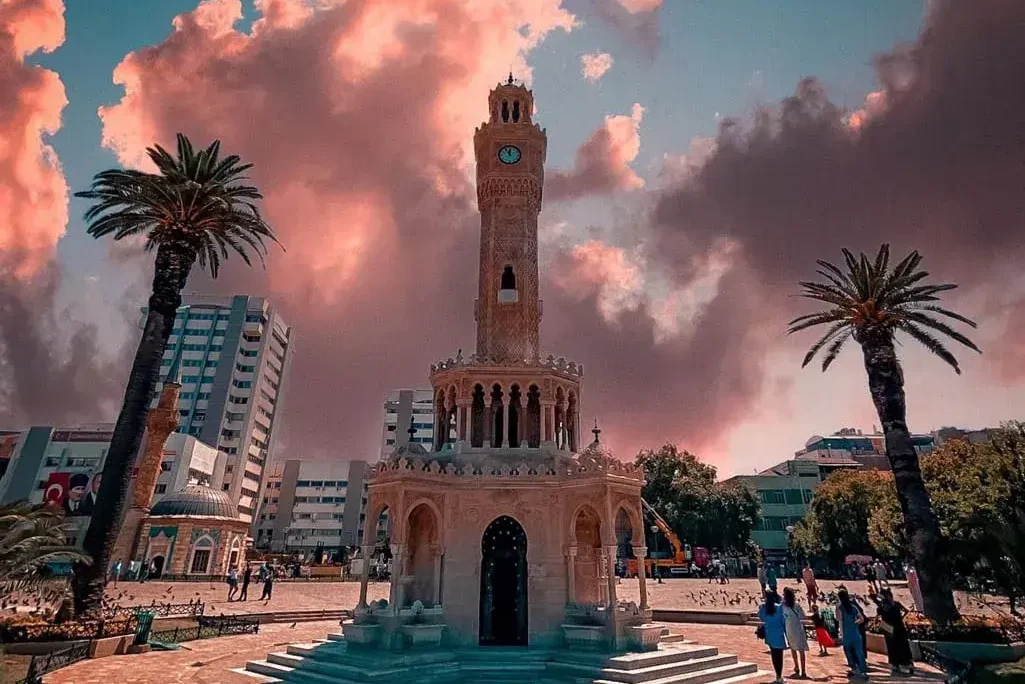 Türkiye'nin Konak Meydanı'ndaki İzmir Saat Kulesi, etkileyici gün batımı gökyüzünün altında.