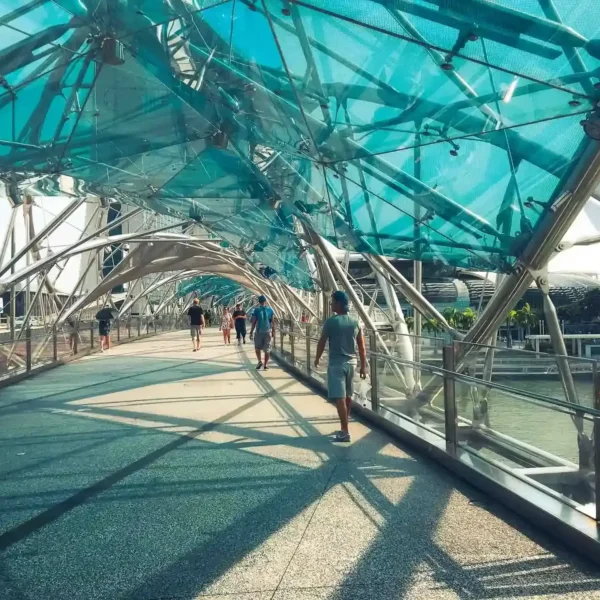 Singapur'da modern köprüde yürüyen insanlar