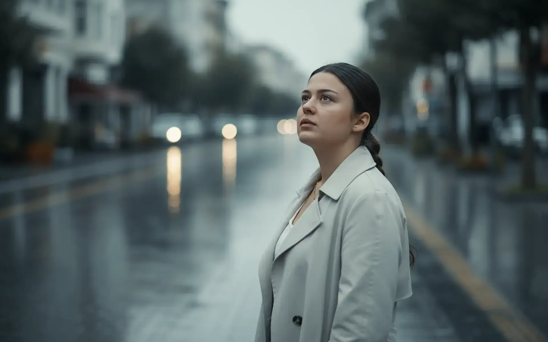 Yağmurlu şehirde dijital fotoğraf sanatı üzerine düşünen genç kadın. Fotoğraf sanatı ve galeriler üzerine bir çalışma.