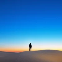 Kum tepesinde duran silüet, negatif alan ve kompozisyonda boşluk kullanımı örneği.